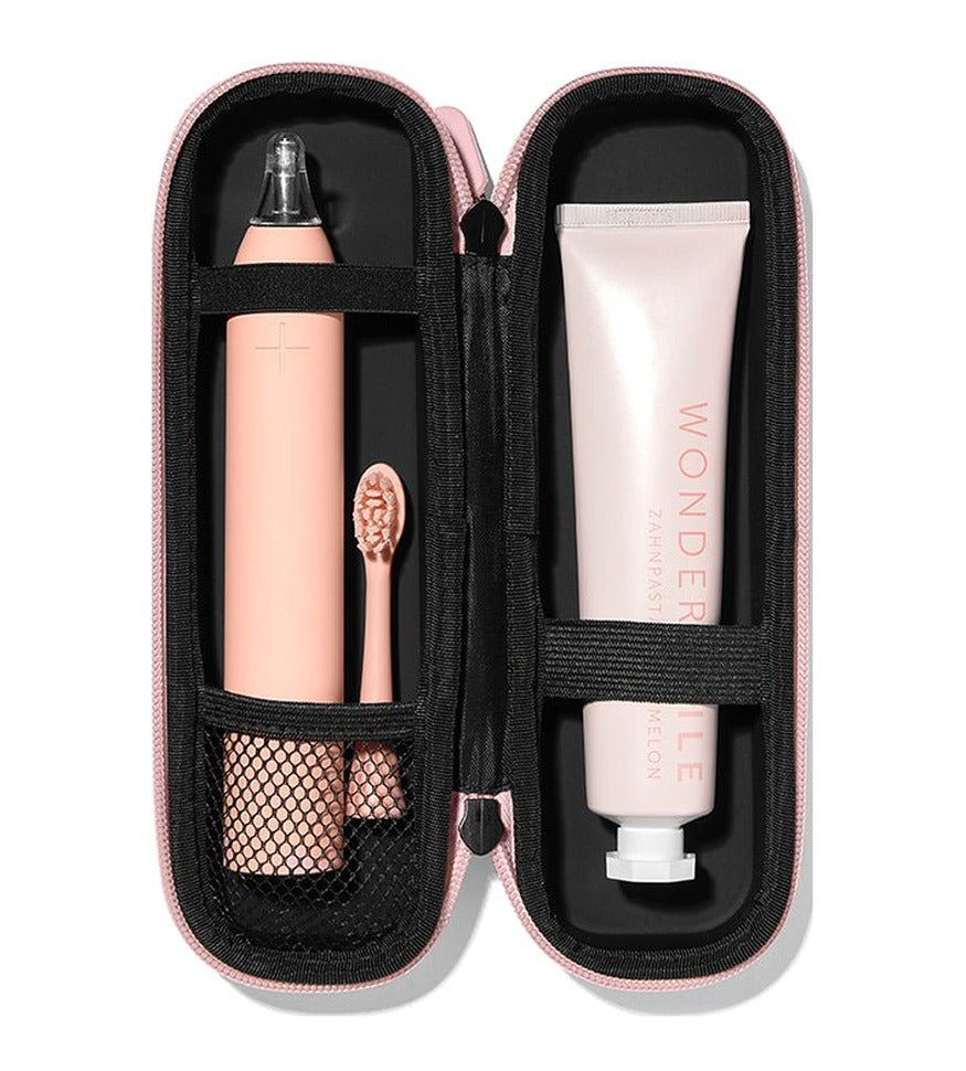 Geöffnetes rosé Reise-Etui für die Wondersmile PRO mit separaten Plätzen für Handstück, Bürstenkopf und Zahnpasta.