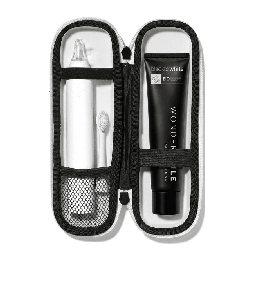 Geöffnetes weißes Reise-Etui für die Wondersmile PRO mit separaten Plätzen für Handstück, Bürstenkopf und Zahnpasta.